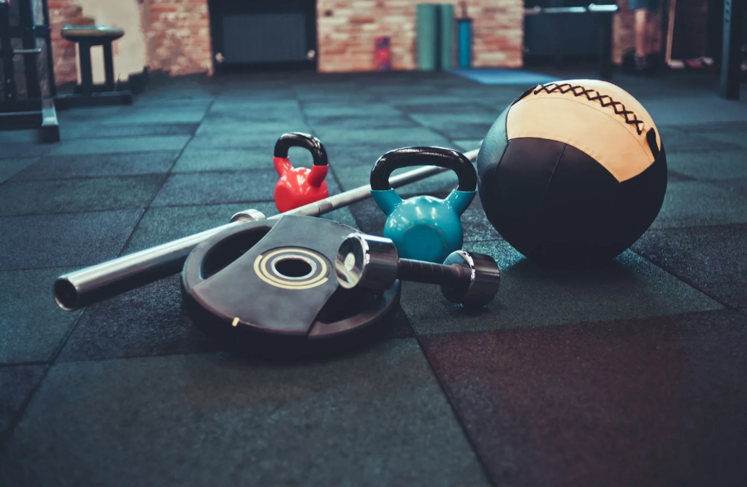 Attrezzature fitness appoggiate sulla pavimentazione antitrauma 